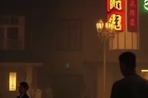 退潮后的滩涂上一个人弯腰拾起半枚贝壳,裤脚沾着湿沙